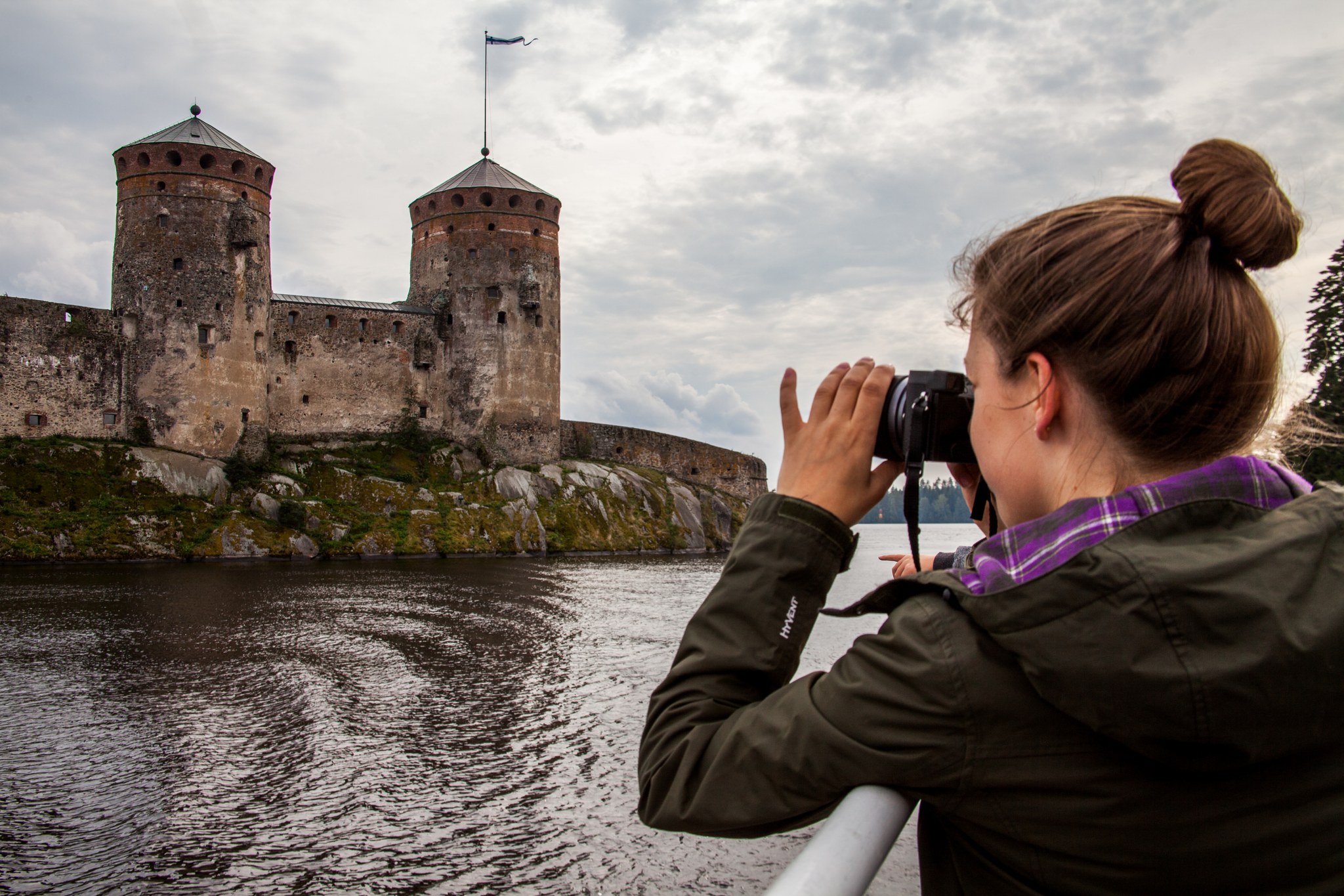 Nainen kuvaa Olavinlinnaa